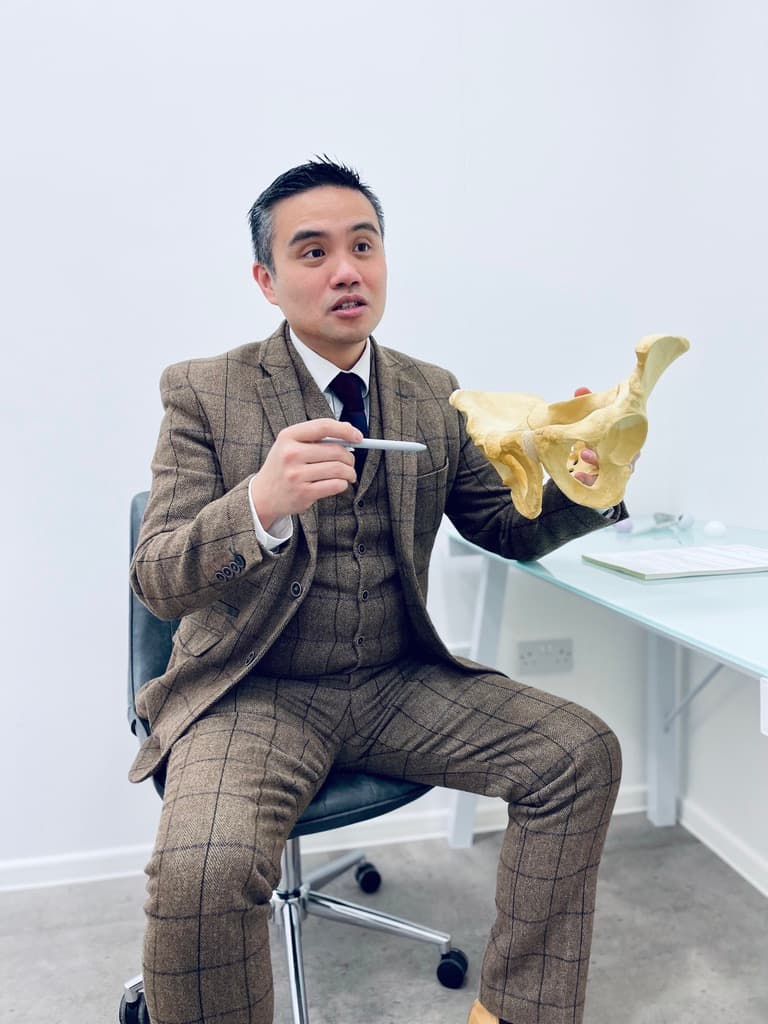 Surgeon demonstrating hip anatomy on a pelvic model