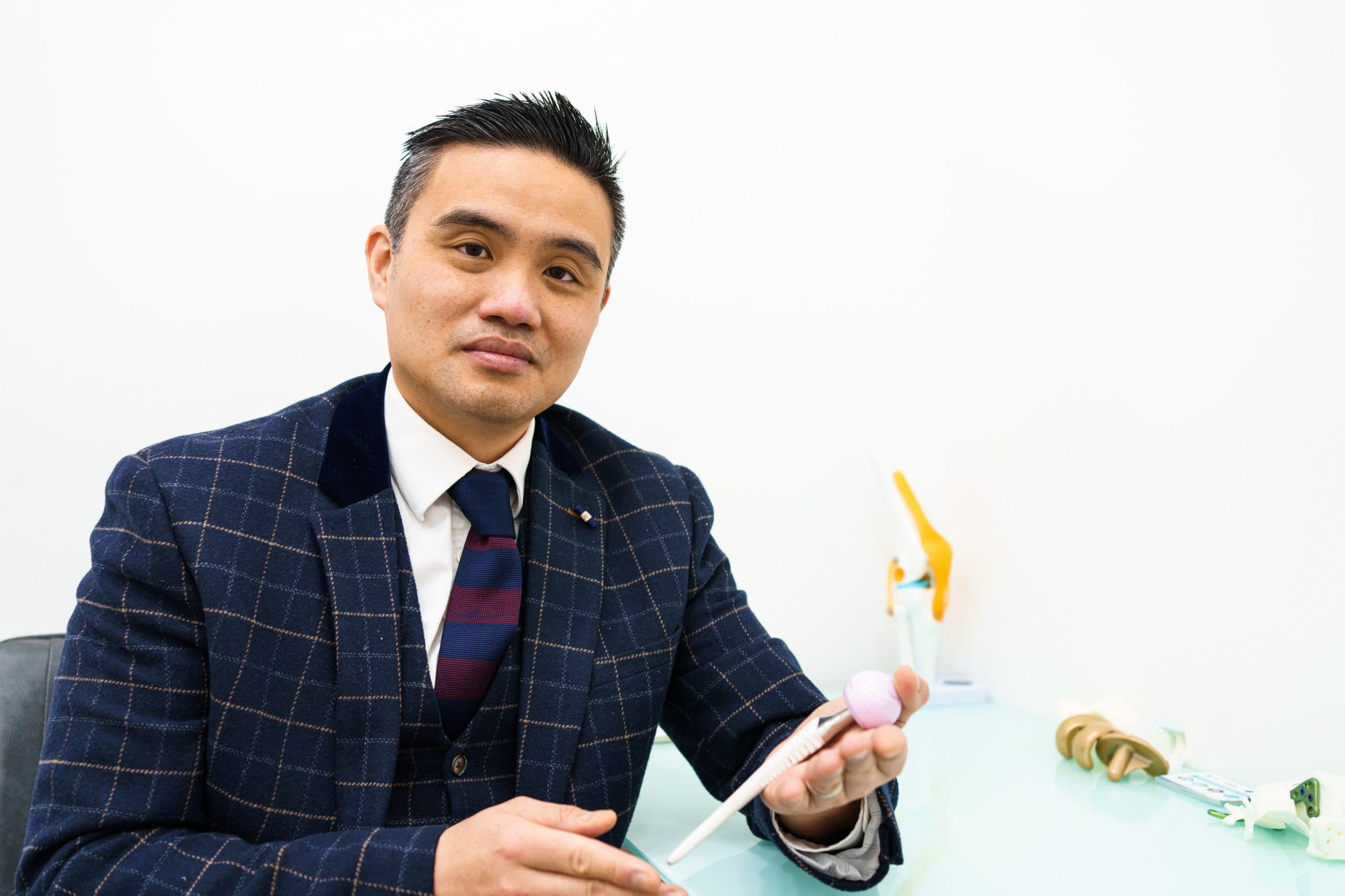Surgeon presenting a knee anatomy model during a consultation